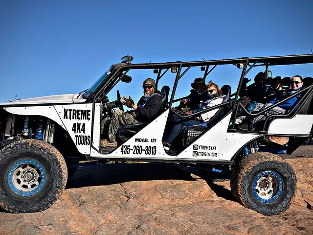 Passagiere sitzen während einer Tour in einem offenen Offroad-Fahrzeug.